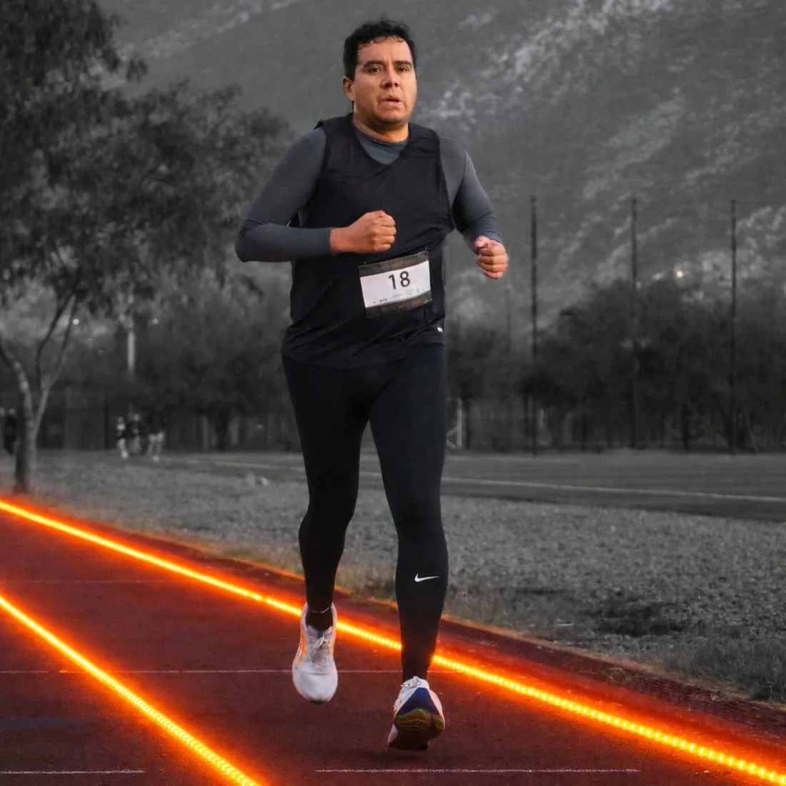 Alex, fundador de Padres Deportistas, corriendo en una pista de atletismo en Monterrey al amanecer